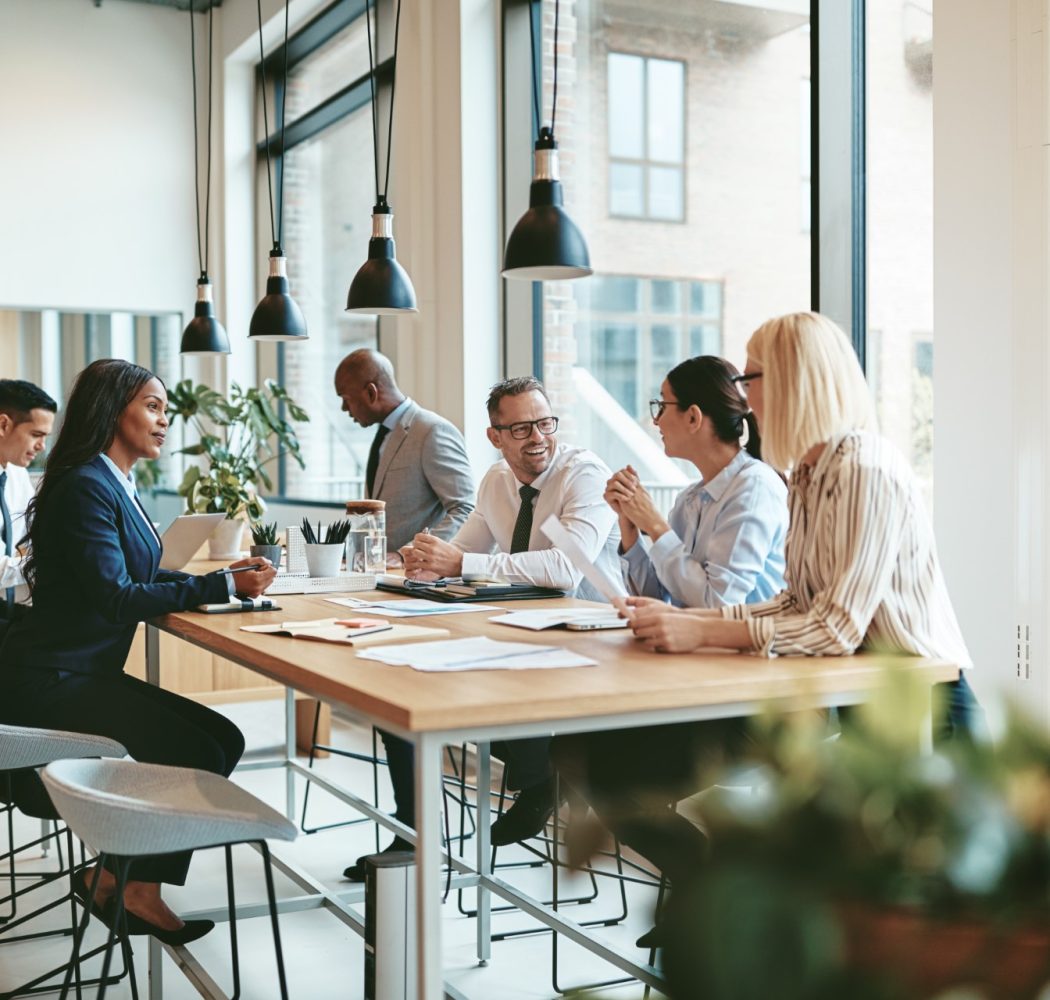 diverse-businesspeople-smiling-and-talking-togethe-HVNBVVR.jpg
